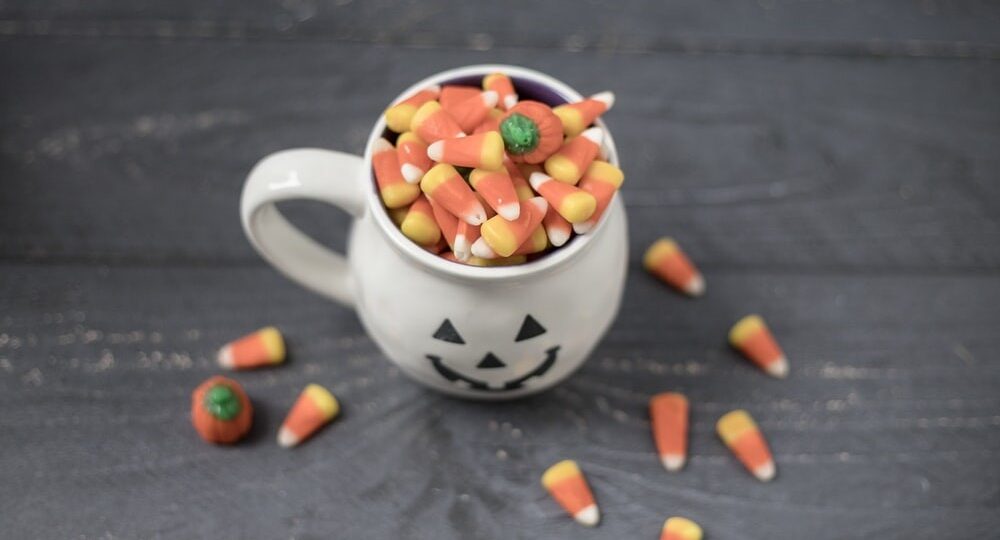 How to Clean Your Floors After Halloween? 1 Halloween mug full of candy corn on a wooden floor